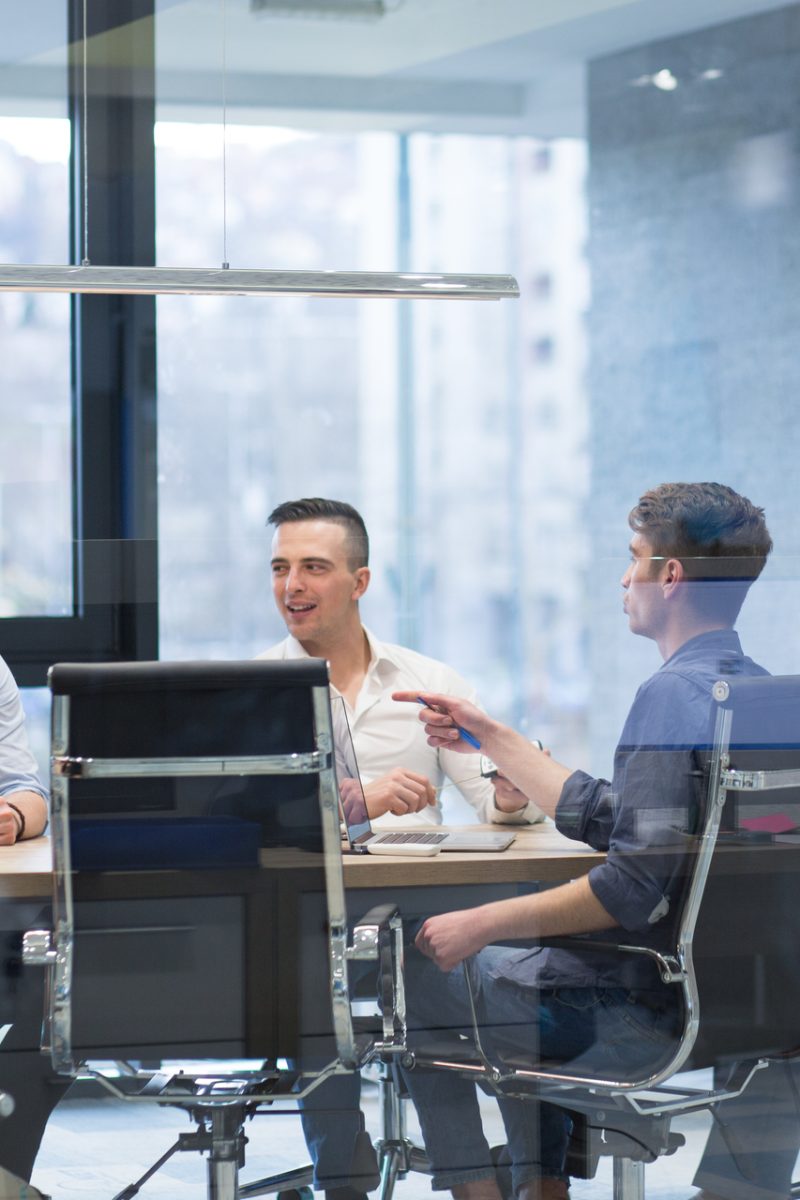 Group of a young business people discussing business plan at modern startup office building